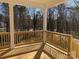 A charming wooden back porch featuring square columns and railing with view of the backyard and wooded area at 148 Dabbling Duck Cir, Mooresville, NC 28117