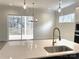 Gourmet kitchen with quartz countertops, stainless steel sink, and access to an outdoor deck at 148 Dabbling Duck Cir, Mooresville, NC 28117