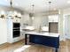 Spacious kitchen with white cabinets, a navy island, quartz countertops, and stainless steel appliances at 148 Dabbling Duck Cir, Mooresville, NC 28117