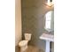 Charming powder room with decorative wall trim, pedestal sink, and wood-look floors at 148 Dabbling Duck Cir, Mooresville, NC 28117