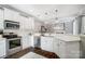 Modern white kitchen with stainless steel appliances, subway tile, quartz counters, and elegant pendant lighting at 2315 Smith Harbour Dr, Denver, NC 28037