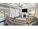 Bright living room featuring coffered ceilings, large windows, a fireplace, and a stylish leather sectional sofa at 2315 Smith Harbour Dr, Denver, NC 28037