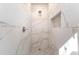 Walk-in shower with marble tile, pebble flooring, and a niche at 10221 Hanging Moss Trl, Charlotte, NC 28227