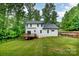 Well-maintained backyard with a wooden deck and partial fencing, surrounded by mature trees at 10221 Hanging Moss Trl, Mint Hill, NC 28227