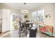 Sunlit dining area with modern table, chairs, and stylish decor with a view to a wooded area at 10221 Hanging Moss Trl, Mint Hill, NC 28227