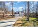 A beautiful home with a long driveway and a vibrant yellow door surrounded by lush trees at 10221 Hanging Moss Trl, Mint Hill, NC 28227