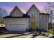 Charming home boasting a two-car garage and a vibrant yellow front door under a twilight sky at 10221 Hanging Moss Trl, Mint Hill, NC 28227