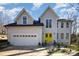 Charming home boasting a two-car garage and a vibrant yellow front door under a bright blue sky at 10221 Hanging Moss Trl, Mint Hill, NC 28227