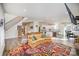 Bright living room showcasing a colorful rug, fireplace, staircase, and open access to the kitchen at 10221 Hanging Moss Trl, Mint Hill, NC 28227