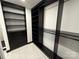 Large walk-in closet features black storage shelves and drawers, and marble floors at 18731 Ramsey Cove Dr # 72, Cornelius, NC 28031