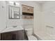 A bathroom with a white tub, white subway tile, wooden vanity, and a wooden wall cabinet at 2505 Ashford Dr, Newton, NC 28658