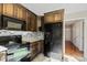 Kitchen featuring black refrigerator and appliances, wood cabinets, and stone backsplash at 2505 Ashford Dr, Newton, NC 28658