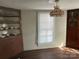 Living room featuring hardwood floors, a window with blinds, custom-built storage, and a unique light fixture at 105 Beaver St, China Grove, NC 28023