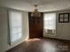 Living room featuring hardwood floors, and two windows with blinds, custom-built storage, and a unique light fixture at 105 Beaver St, China Grove, NC 28023