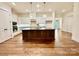 Modern kitchen with white cabinets, large island, and hardwood floors at 166 Fulworth Nw Dr # 67, Concord, NC 28027