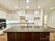 Modern kitchen with white cabinets, a large island, and hardwood floors at 166 Fulworth Nw Dr # 67, Concord, NC 28027