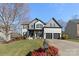 Two-story home with gray and white exterior, two-car garage, and landscaped yard at 1811 Robbins Meadows Dr, Waxhaw, NC 28173