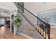 Modern staircase with black railing and stone accent wall at 1811 Robbins Meadows Dr, Waxhaw, NC 28173