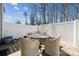 Private backyard patio enclosed by a white fence, featuring a table with four chairs at 7122 Abbotts Glen Dr, Charlotte, NC 28212