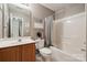 Bathroom featuring a shower-tub combo, oak vanity, and bright vanity lighting at 7122 Abbotts Glen Dr, Charlotte, NC 28212