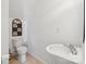 Cozy half bath with a pedestal sink, toilet, and decorative wall art at 7122 Abbotts Glen Dr, Charlotte, NC 28212