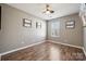 Minimalist bedroom with wood floors, neutral paint, ceiling fan and a bright window at 7122 Abbotts Glen Dr, Charlotte, NC 28212