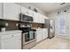 Bright kitchen featuring white cabinets, stainless steel appliances, tile floors, and access to the backyard at 7122 Abbotts Glen Dr, Charlotte, NC 28212