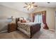 Cozy main bedroom with ceiling fan, nightstands, and window with patterned valance and drapes at 7122 Abbotts Glen Dr, Charlotte, NC 28212