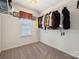 Spacious walk-in closet offering ample storage with shelving, hanging rods, and a window for natural light at 7122 Abbotts Glen Dr, Charlotte, NC 28212