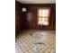 Living room featuring wood walls and damaged tile floor at 111 James Love School Rd, Shelby, NC 28152