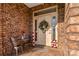 Inviting front entrance with brick facade, a wreath, and small patio set at 1490 Kensington Park Ct, Hickory, NC 28602