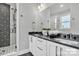 Modern bathroom featuring dual sinks, white cabinetry, and a stylish shower with geometric tile design at 3614 S Tryon St # 18, Charlotte, NC 28217