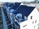 Aerial view of modern townhomes featuring rooftop terraces with stylish outdoor furniture and sleek, dark roofs at 3614 S Tryon St # 18, Charlotte, NC 28217