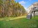 Backyard with grassy area, wooden stairs leading to deck, and trees at 9507 Inverness Bay Rd, Charlotte, NC 28278