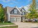 Two-story house with gray siding, stone accents, and a two-car garage at 9507 Inverness Bay Rd, Charlotte, NC 28278