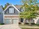 Two-story home with gray siding, stone accents, and a two-car garage at 9507 Inverness Bay Rd, Charlotte, NC 28278