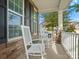 Relaxing front porch with white rocking chairs and stone accents at 9507 Inverness Bay Rd, Charlotte, NC 28278