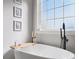 Close up of modern tub and fixtures next to bright window at 111 Alberta Ave, Belmont, NC 28012