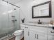 Modern bathroom with glass-enclosed shower, granite countertop, and sleek black fixtures at 111 Alberta Ave, Belmont, NC 28012