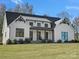 Beautiful white farmhouse with black trim, covered porch, and lush green lawn at 111 Alberta Ave, Belmont, NC 28012