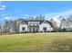 A white farmhouse with black trim sits on a large lot with a well-manicured lawn at 111 Alberta Ave, Belmont, NC 28012