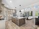 A grand kitchen island opens to an airy living room with a fireplace and vaulted ceiling at 111 Alberta Ave, Belmont, NC 28012