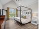 Primary bedroom featuring vaulted ceiling, hardwood floors, a four-poster bed, and a large window at 111 Alberta Ave, Belmont, NC 28012