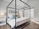 Primary bedroom featuring vaulted ceiling, hardwood floors, four-poster bed, and ensuite bathroom at 111 Alberta Ave, Belmont, NC 28012