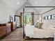 Primary bedroom featuring vaulted ceiling, hardwood floors, four-poster bed, and bright natural light at 111 Alberta Ave, Belmont, NC 28012