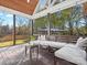 Comfortable screened porch boasts wooden floors, bench seating, and scenic backyard views at 111 Alberta Ave, Belmont, NC 28012