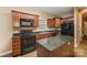 Modern kitchen features dark wood cabinets, granite countertops and black appliances at 119 Lookout Point Pl, Mooresville, NC 28115