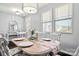 Elegant dining room with a long table, white chairs, and a chandelier at 1969 Tablerock Dr, Lake Wylie, SC 29745