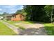 The exterior view of the home features a large driveway leading to a single-story brick home surrounded by mature trees at 2319 Tin Mine Rd, Lincolnton, NC 28092