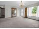 Bright living room with chandelier, large window, and display cabinet; ready for your decor at 2319 Tin Mine Rd, Lincolnton, NC 28092